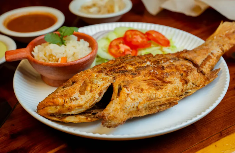 Grilled whole fish with rice, salad, and salsa at Lupita's