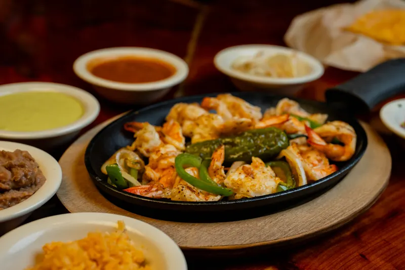 A sizzling skillet with vegetables and side dishes